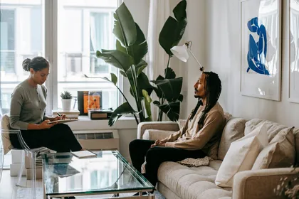A calm one-on-one conversation in a plant-filled, naturally lit room
