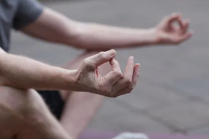 Close-up of hands resting in a relaxed meditation gesture